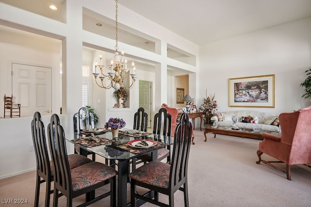 dining room with carpet and an inviting chandelier