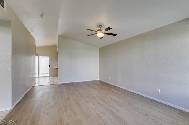 empty room with lofted ceiling, light wood-type flooring, and ceiling fan