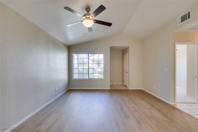 spare room with ceiling fan, lofted ceiling, and light wood-type flooring