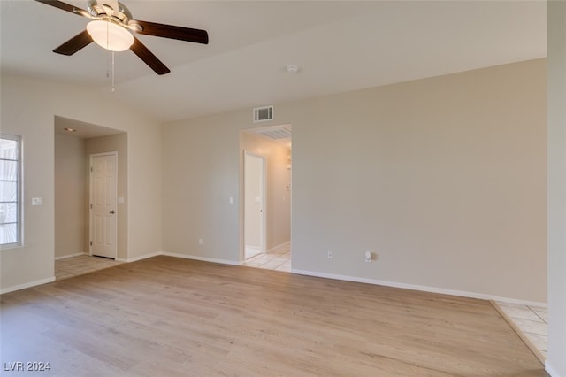 empty room with vaulted ceiling, light hardwood / wood-style flooring, and ceiling fan