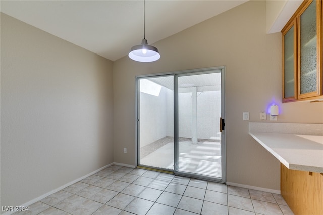 unfurnished dining area with lofted ceiling and light tile patterned floors