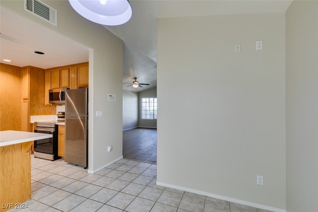 kitchen with stainless steel appliances, light tile patterned floors, and ceiling fan