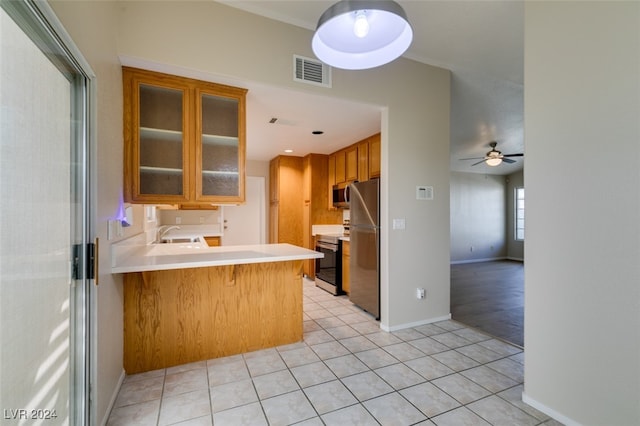 kitchen featuring a breakfast bar area, appliances with stainless steel finishes, kitchen peninsula, and light tile patterned floors