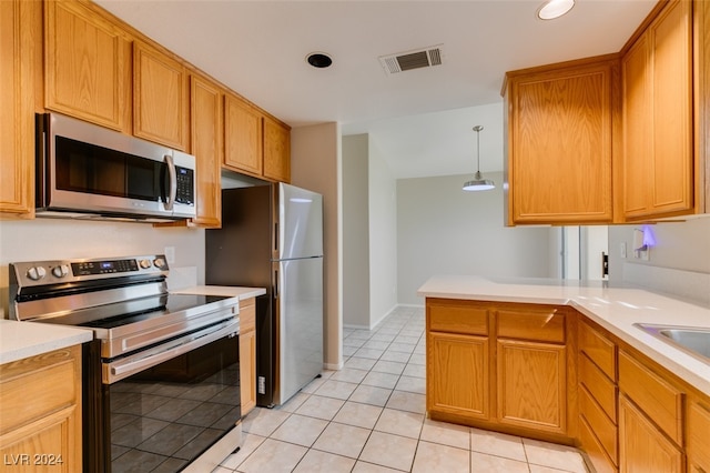 kitchen featuring appliances with stainless steel finishes, kitchen peninsula, pendant lighting, and light tile patterned flooring