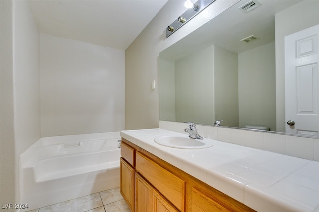 bathroom featuring vanity, toilet, a bath, and tile patterned flooring