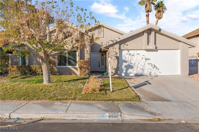 view of front of home with a front yard and a garage