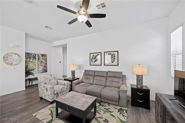 living room featuring dark wood-type flooring and ceiling fan