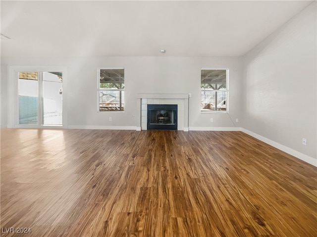 unfurnished living room with a wealth of natural light, hardwood / wood-style floors, and a fireplace