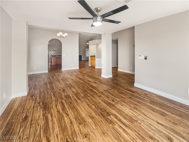 unfurnished living room with wood-type flooring and ceiling fan with notable chandelier