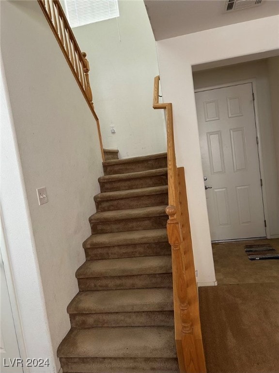 staircase featuring carpet