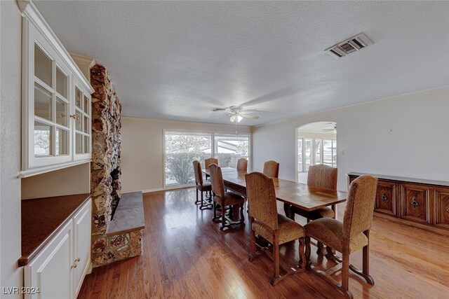 dining room with ceiling fan, light hardwood / wood-style floors, and a textured ceiling