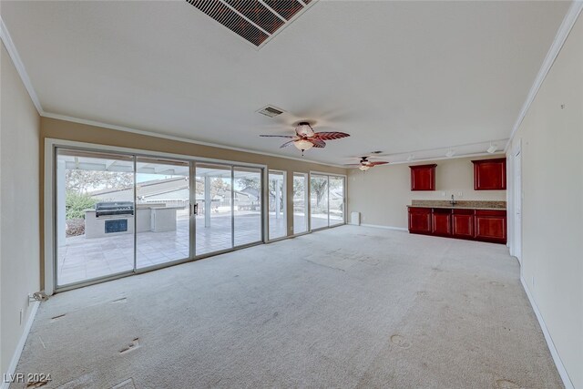 unfurnished living room with ceiling fan, crown molding, light carpet, and track lighting