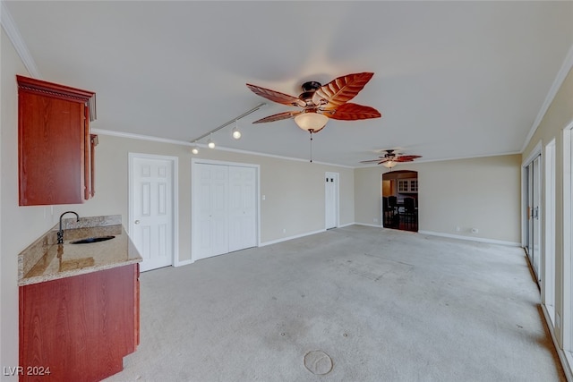 unfurnished living room with ornamental molding, sink, and light carpet