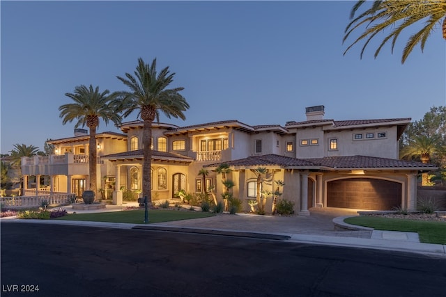 mediterranean / spanish-style home featuring a garage and a balcony