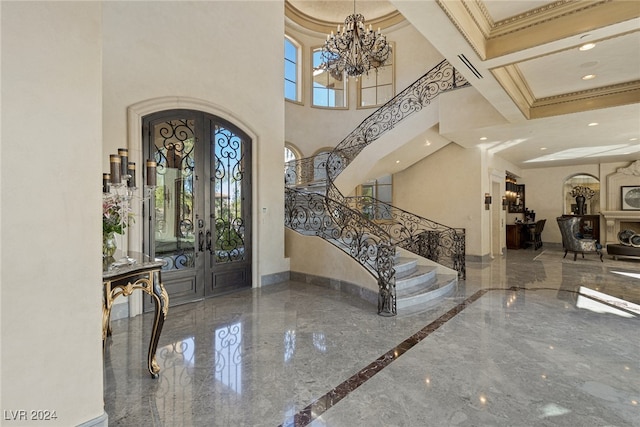 foyer entrance featuring french doors, coffered ceiling, a high ceiling, beamed ceiling, and ornamental molding