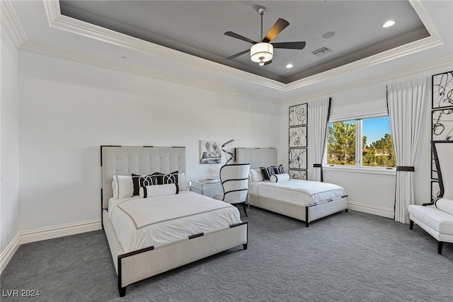 carpeted bedroom with ceiling fan, a raised ceiling, and ornamental molding