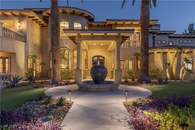 view of front of home with a front yard and a balcony