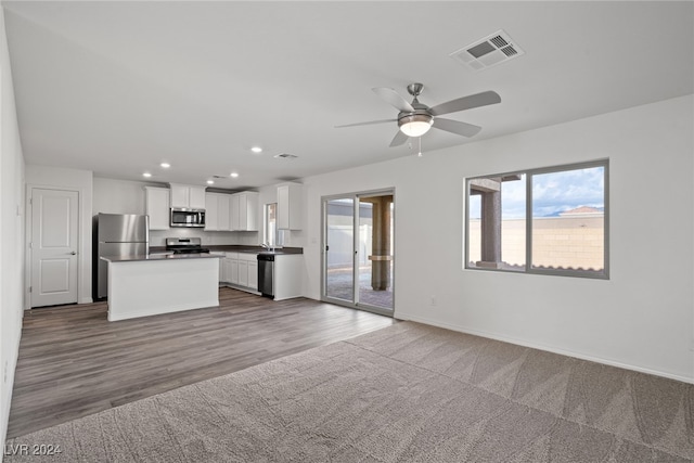 kitchen featuring appliances with stainless steel finishes, a center island, ceiling fan, white cabinets, and light hardwood / wood-style flooring