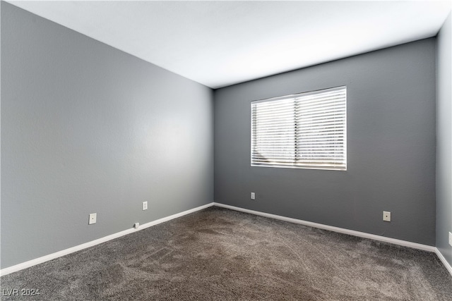 spare room with dark carpet