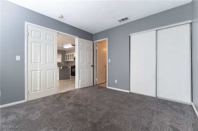 unfurnished bedroom with carpet floors and a closet