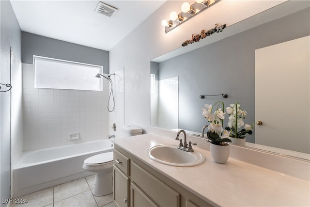 full bathroom with tile patterned flooring, vanity, tiled shower / bath combo, and toilet