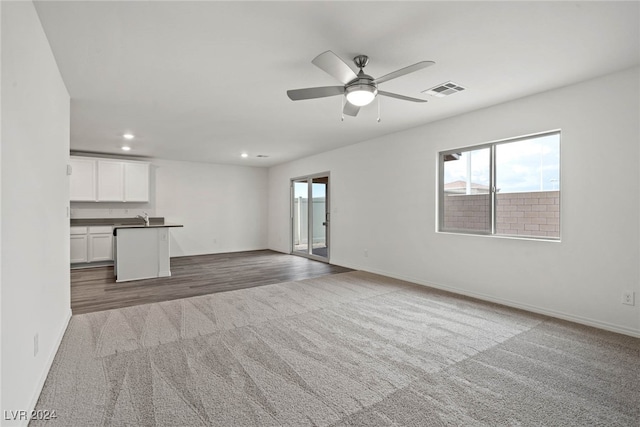 unfurnished living room with sink, ceiling fan, and dark hardwood / wood-style flooring