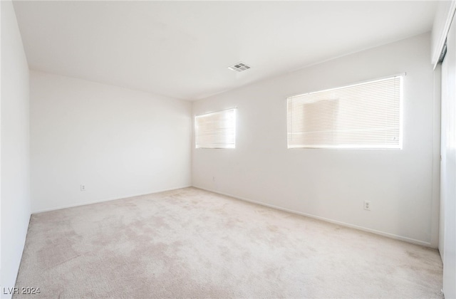 unfurnished room featuring light colored carpet