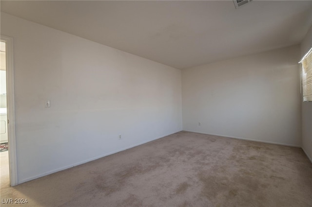 unfurnished room with light colored carpet and washer / clothes dryer