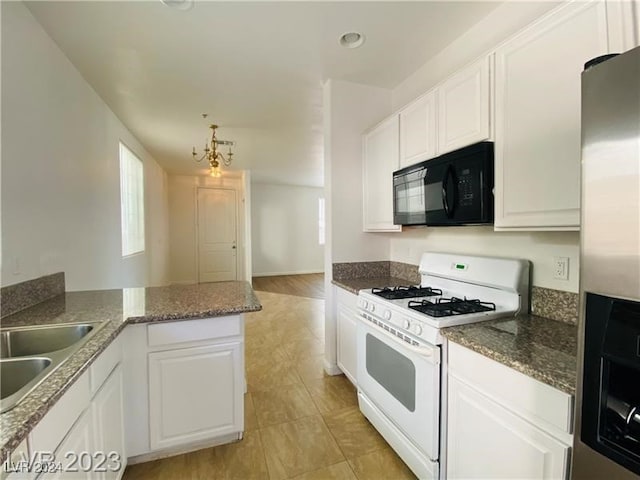 kitchen featuring white range with gas cooktop, white cabinets, kitchen peninsula, a chandelier, and sink