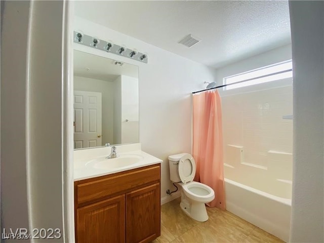 full bathroom with vanity, toilet, a textured ceiling, and shower / bath combo