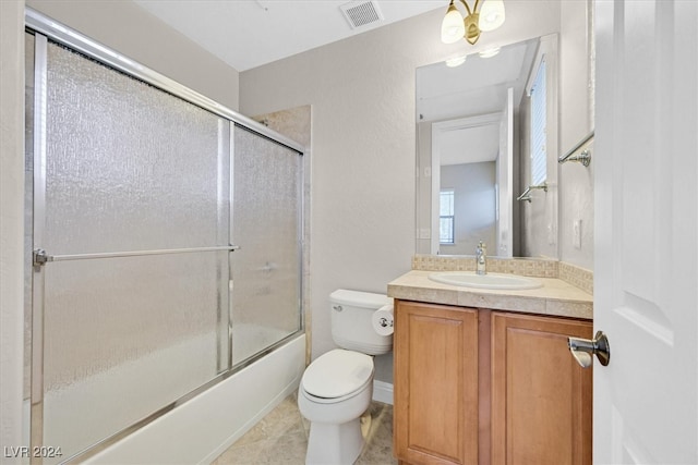 full bathroom featuring vanity, combined bath / shower with glass door, toilet, and tile patterned floors