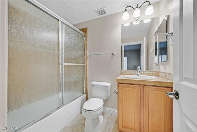 full bathroom with vanity, enclosed tub / shower combo, toilet, and tile patterned floors