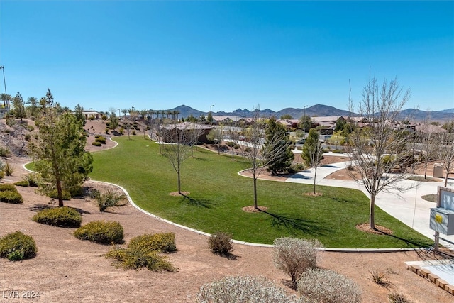 surrounding community with a mountain view and a lawn