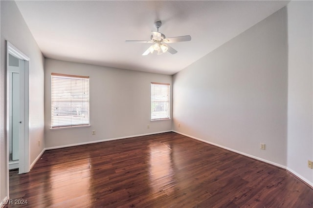 spare room featuring ceiling fan, baseboards, and dark wood finished floors