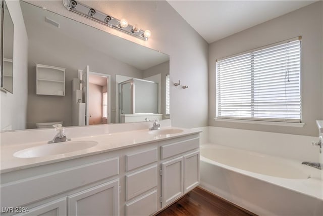 full bathroom with double vanity, a stall shower, a sink, and a bath