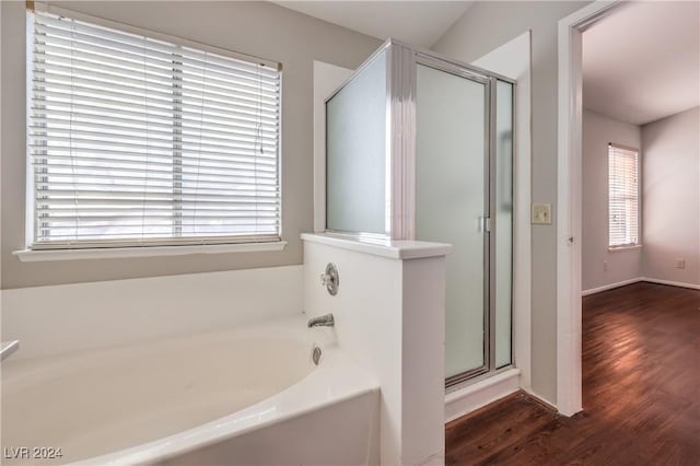 bathroom with a garden tub, wood finished floors, and a stall shower