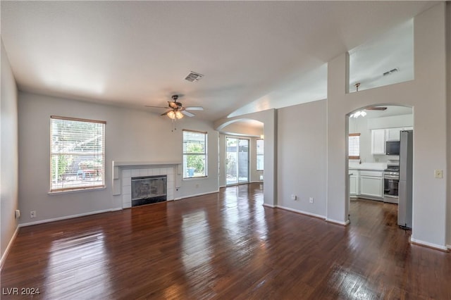 unfurnished living room with visible vents, dark wood finished floors, and a fireplace