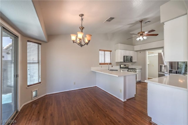 kitchen with a peninsula, a sink, white cabinetry, appliances with stainless steel finishes, and dark wood-style floors