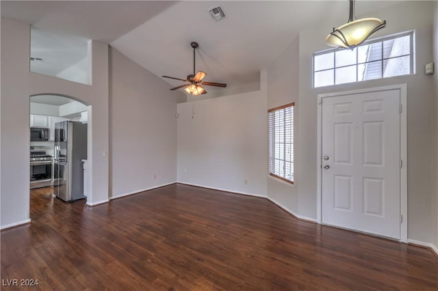 foyer featuring visible vents, arched walkways, dark wood finished floors, a ceiling fan, and high vaulted ceiling