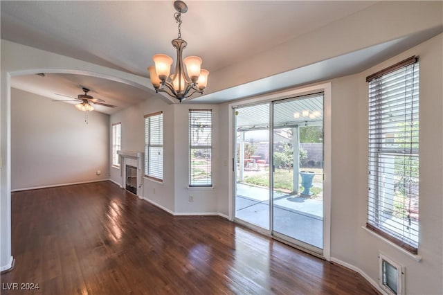 unfurnished room featuring baseboards, a fireplace, arched walkways, and wood finished floors