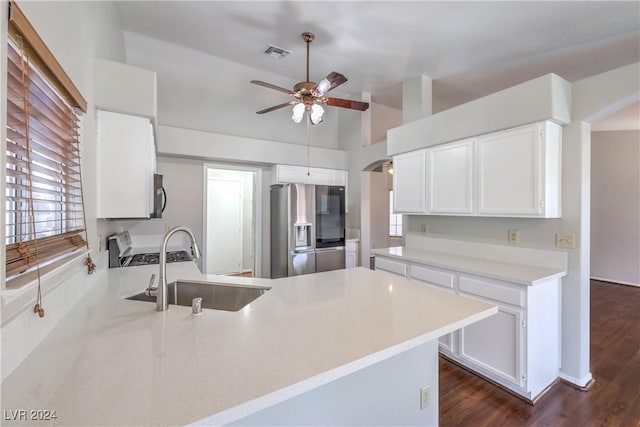 kitchen featuring stainless steel fridge, visible vents, arched walkways, a peninsula, and a sink