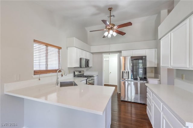 kitchen featuring white cabinets, dark wood finished floors, stainless steel appliances, light countertops, and a sink