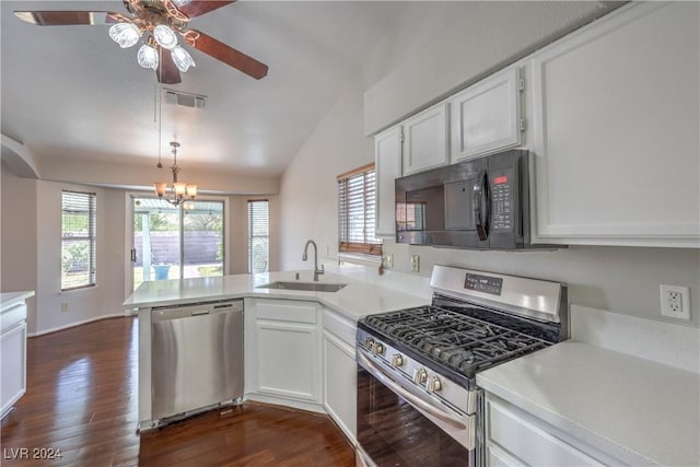 kitchen featuring appliances with stainless steel finishes, a peninsula, vaulted ceiling, light countertops, and a sink