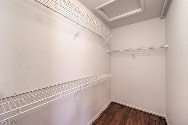 walk in closet featuring dark wood finished floors and attic access