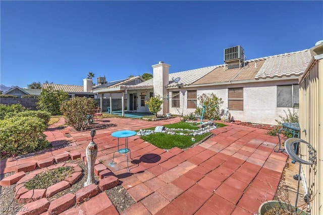 exterior space with stucco siding, a patio area, a tile roof, and central air condition unit