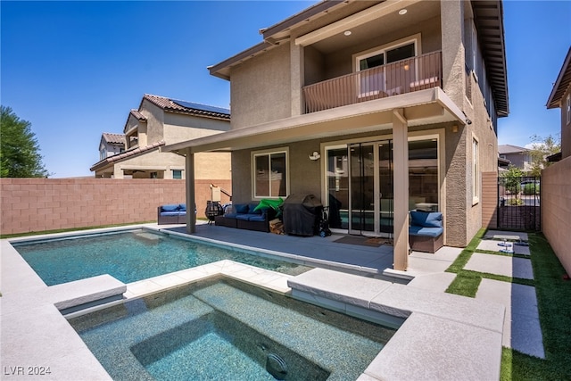 back of house with a balcony, a patio, and a swimming pool with hot tub