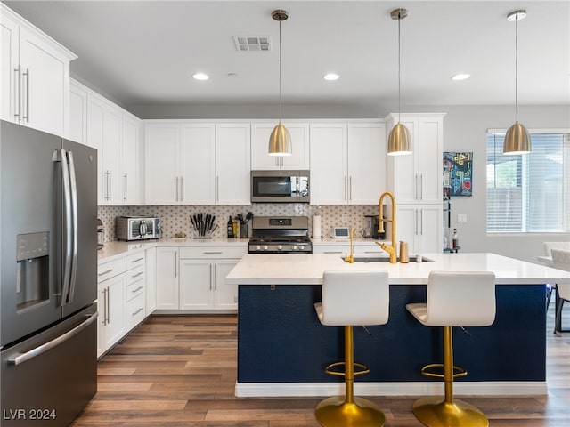 kitchen with dark wood-type flooring, white cabinets, decorative light fixtures, and stainless steel appliances