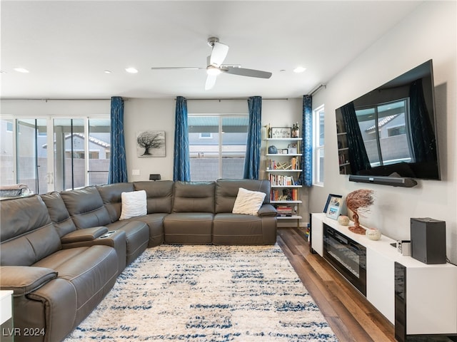 living room featuring dark wood-type flooring and ceiling fan