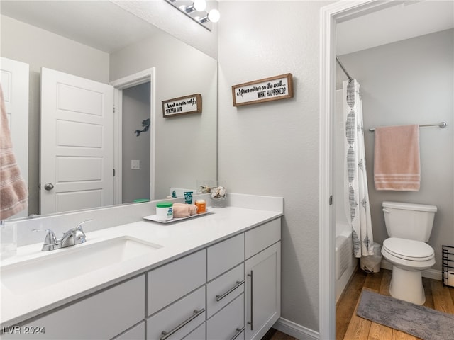 full bathroom featuring shower / bath combo, hardwood / wood-style floors, vanity, and toilet