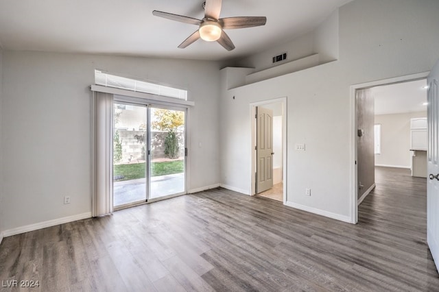 unfurnished bedroom featuring hardwood / wood-style floors, vaulted ceiling, ceiling fan, access to exterior, and connected bathroom